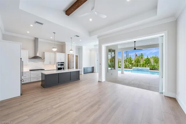 a view of kitchen with kitchen island wooden floor center island and stainless steel appliances