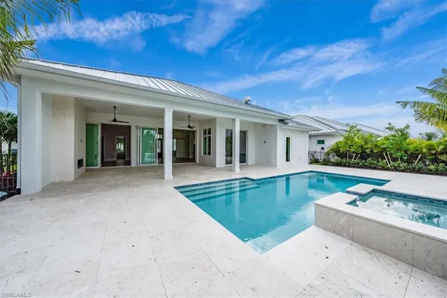 front view of a house with a large window and potted plants