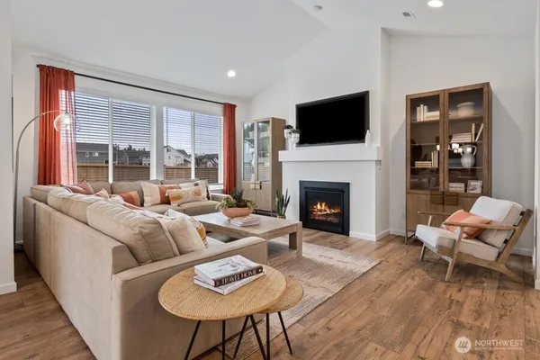 a living room with furniture a flat screen tv and a fireplace