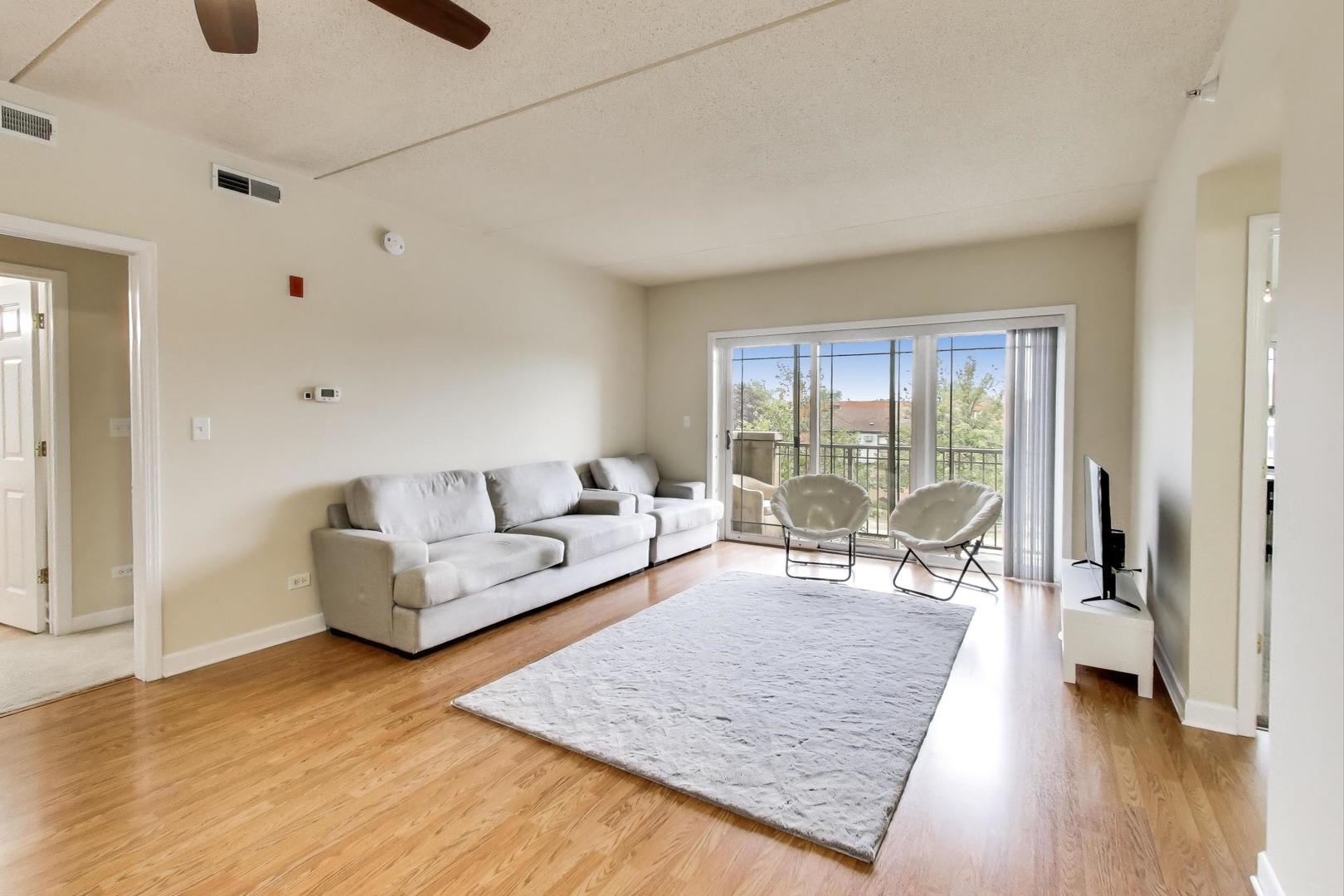 77 North Wolf Road, Unit 312 Melrose Park, IL 60164 - Photo 2 of 20 a living room with furniture and a wooden floor