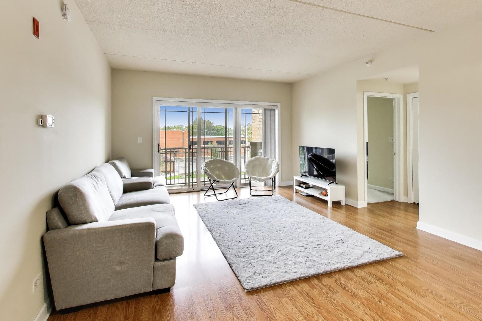 77 North Wolf Road, Unit 312 Melrose Park, IL 60164 - Photo 3 of 20 a living room with furniture and a flat screen tv