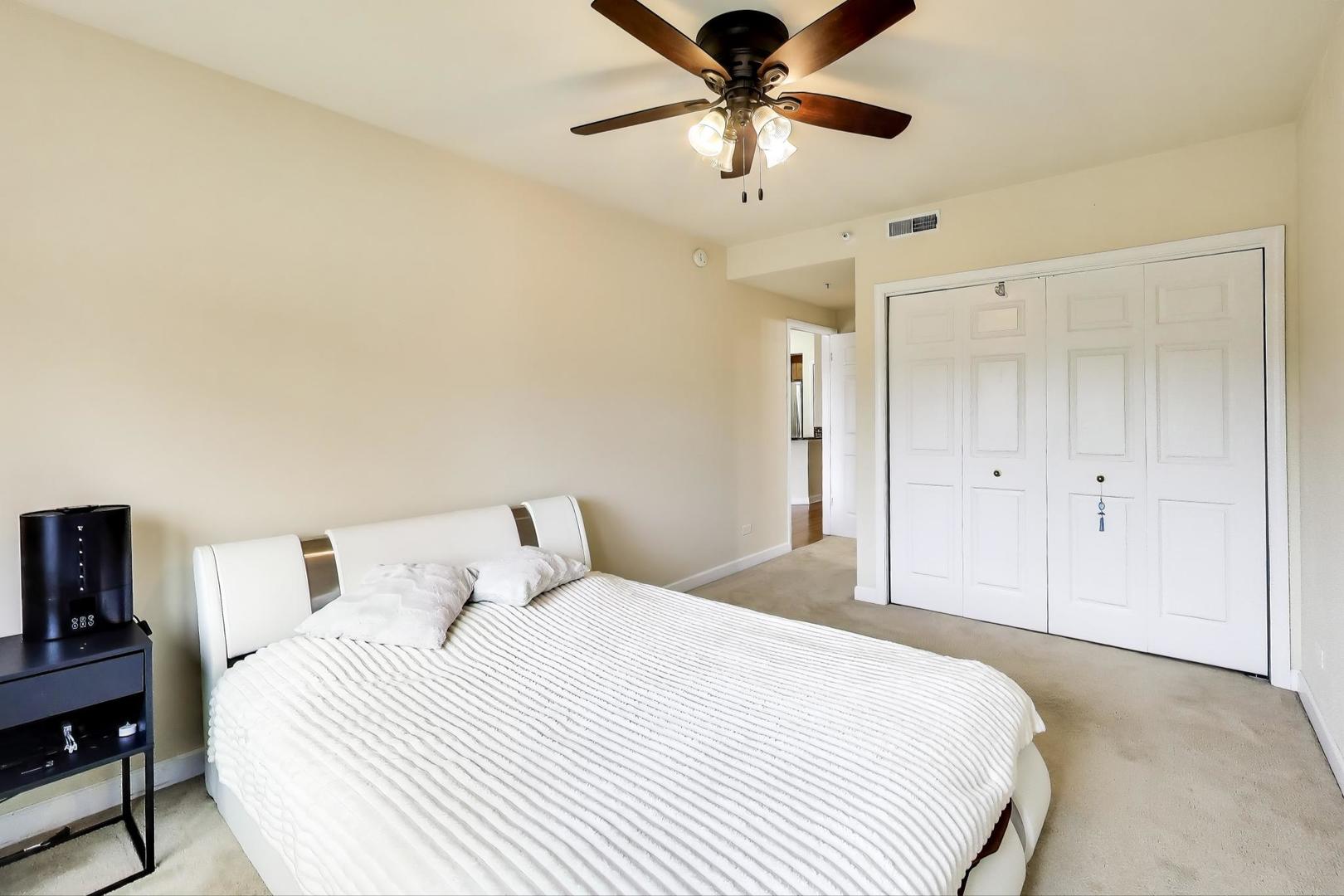 77 North Wolf Road, Unit 312 Melrose Park, IL 60164 - Photo 9 of 20 a bedroom with a bed and a chandelier