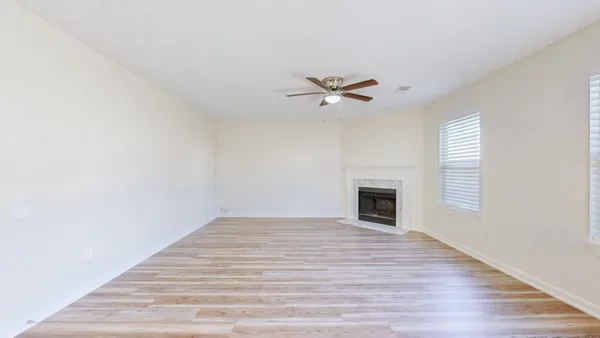 a view of empty room with wooden floor and fireplace