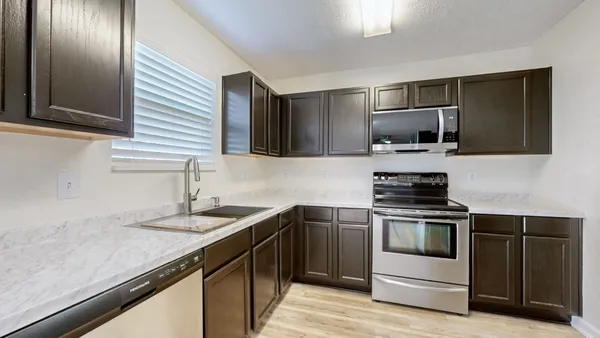 a kitchen with a sink stove and microwave