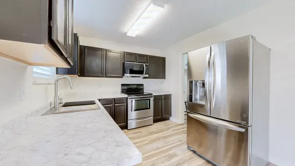 a kitchen with stainless steel appliances granite countertop a refrigerator and a stove top oven