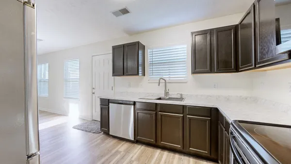 a kitchen with stainless steel appliances granite countertop wooden cabinets a sink and dishwasher