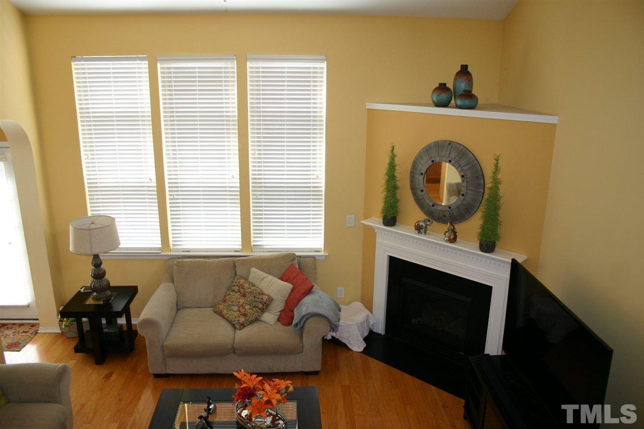 8207 Beaded Stone Street Raleigh, NC 27613 - Photo 12 of 23 a living room with furniture and a fireplace
