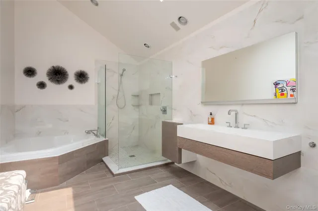 a bathroom with a tub a sink and mirror