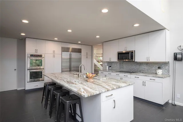 a kitchen with stainless steel appliances kitchen island granite countertop a sink and cabinets