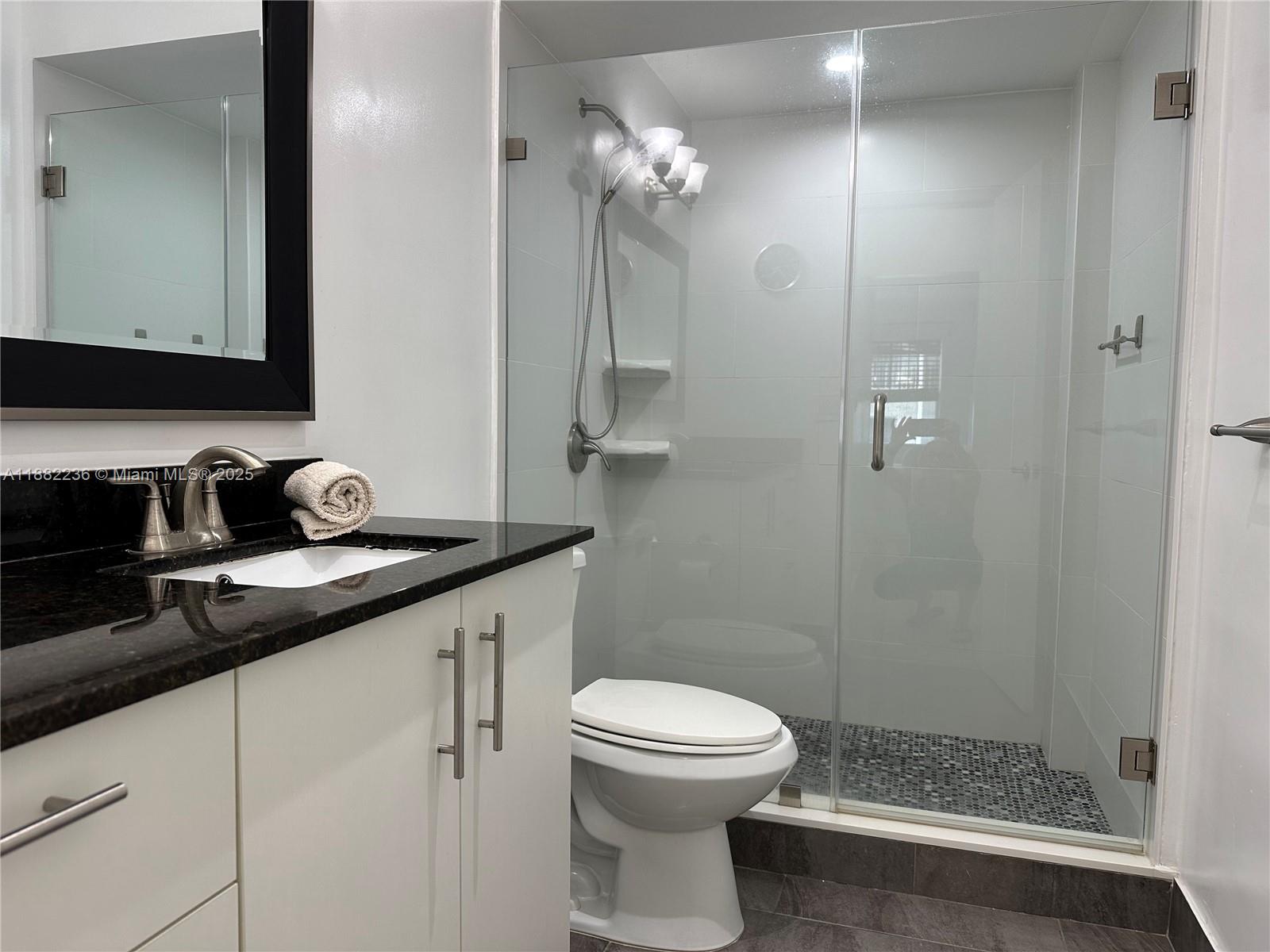 1130 11th Street, Unit 4D Miami Beach, FL 33139 - Photo 7 of 23 a bathroom with a sink a toilet and a mirror