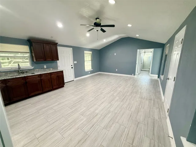 wooden floor in an empty room with a kitchen