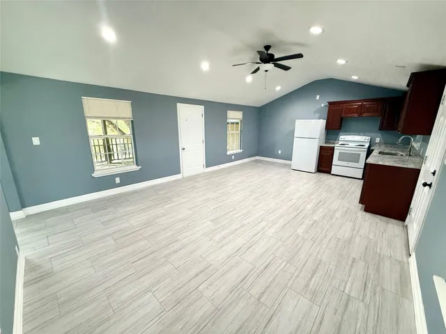 a kitchen with stainless steel appliances granite countertop a refrigerator a sink dishwasher a stove top oven a refrigerator and cabinets with wooden floor