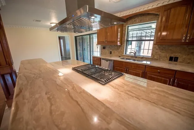 a large kitchen with kitchen island a stove a sink and a cabinets