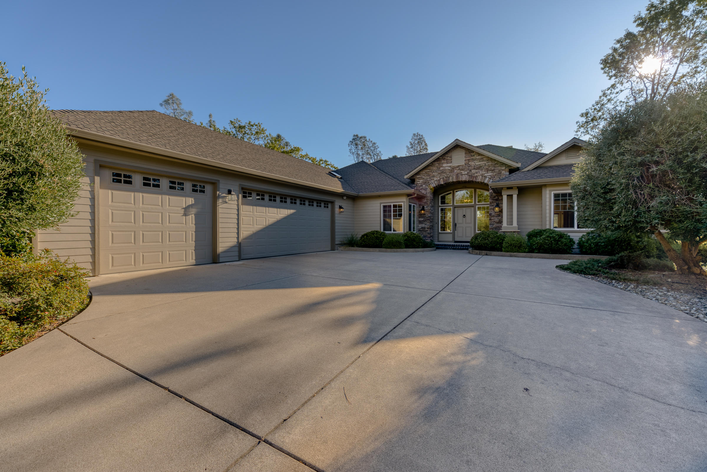 10163 Tilton Mine Road Redding, CA 96001 - Photo 104 of 144 a front view of a house with a garden and trees