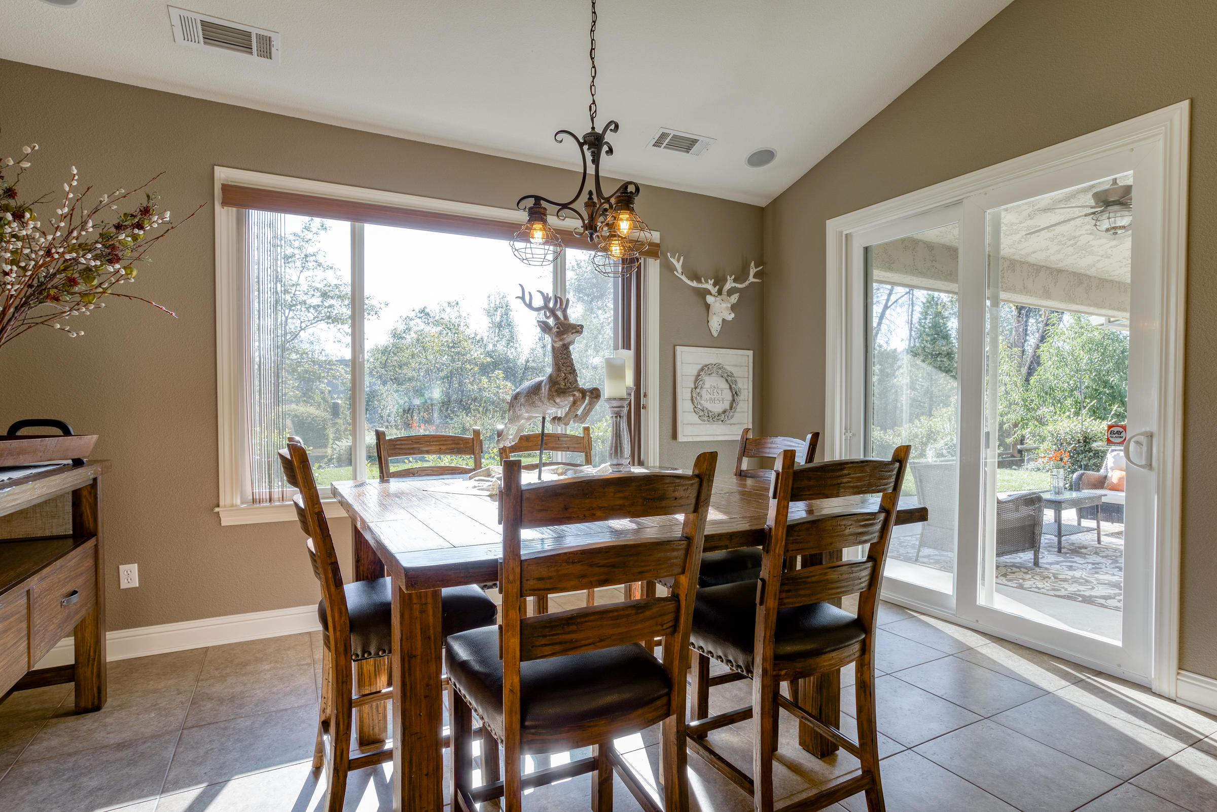 10163 Tilton Mine Road Redding, CA 96001 - Photo 8 of 144 a view of a dining room with furniture large windows and wooden floor