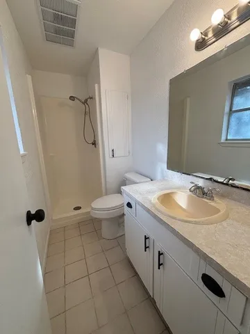 a bathroom with a granite countertop sink a toilet and a mirror