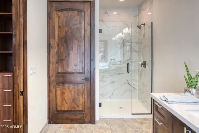 a bathroom with a glass shower door and a sink