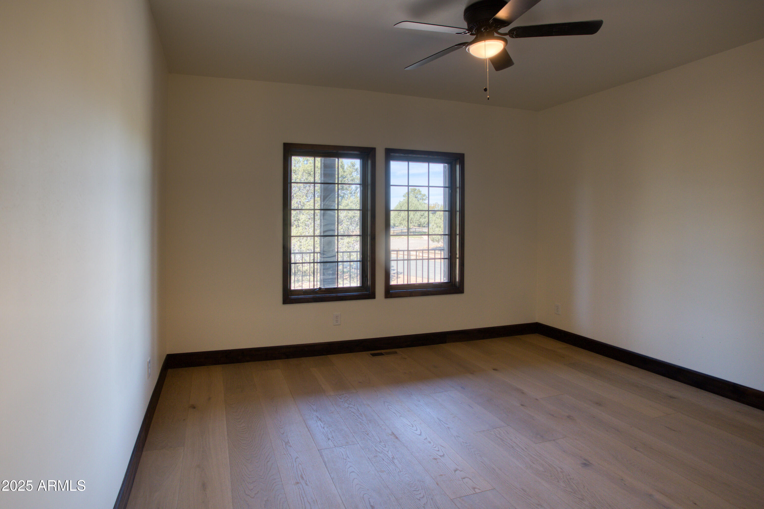 957 Cheney Ranch Loop Show Low, AZ 85901 - Photo 22 of 32 an empty room with wooden floor fan and windows
