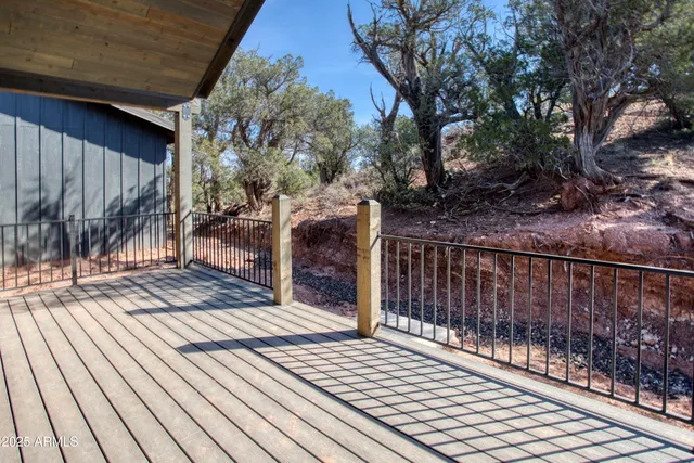 a view of backyard with wooden fence and large trees