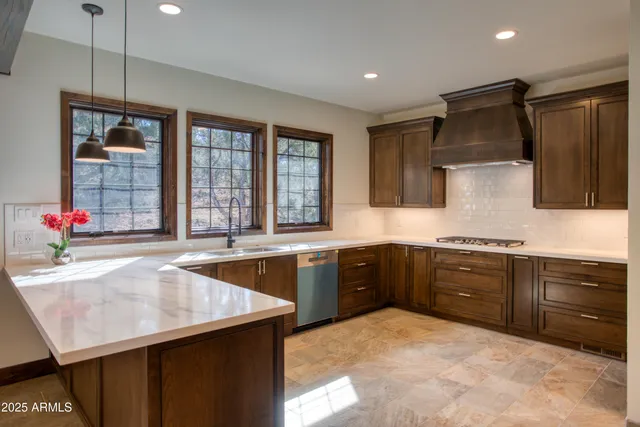 a kitchen with granite countertop a sink stainless steel appliances and cabinets
