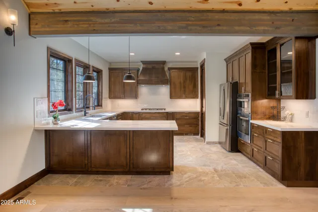 a living room with stainless steel appliances kitchen island granite countertop a sink and cabinets