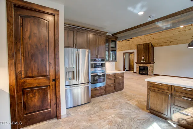 a kitchen with granite countertop stainless steel appliances a refrigerator and cabinets