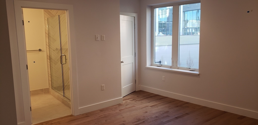 50 Hichborn Street, Unit 311 Boston, MA 02135 - Photo 12 of 19 a view of an empty room with wooden floor and a window