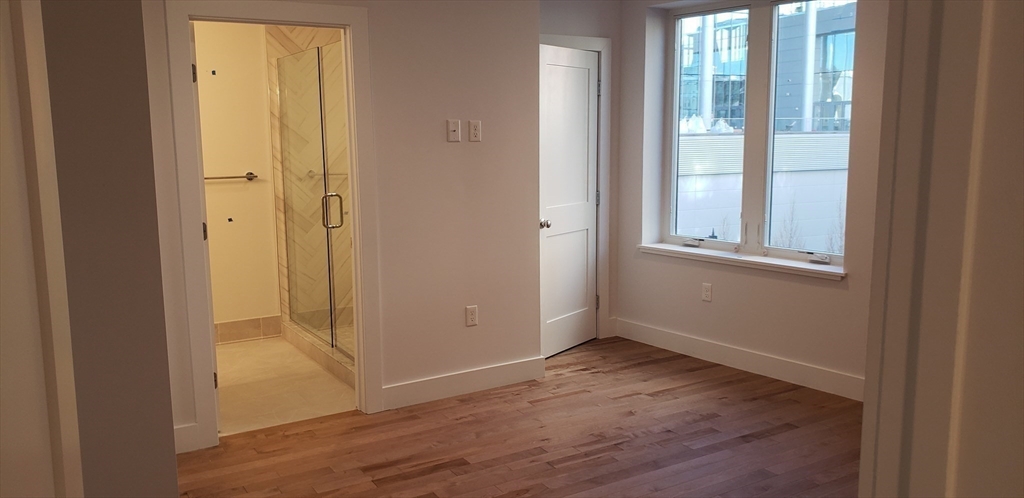 50 Hichborn Street, Unit 311 Boston, MA 02135 - Photo 13 of 19 an empty room with wooden floor and windows