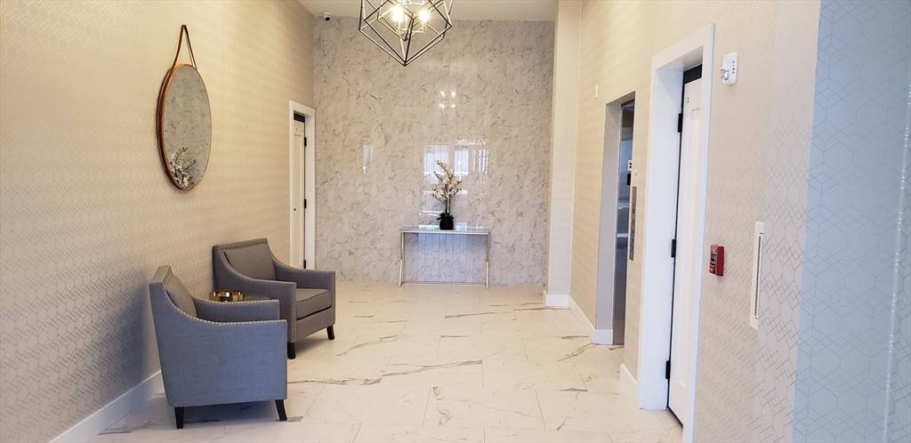 50 Hichborn Street, Unit 311 Boston, MA 02135 - Photo 6 of 19 a view of a hallway with couches and a chandelier