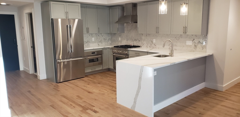 50 Hichborn Street, Unit 311 Boston, MA 02135 - Photo 7 of 19 a kitchen with wooden cabinets and stainless steel appliances