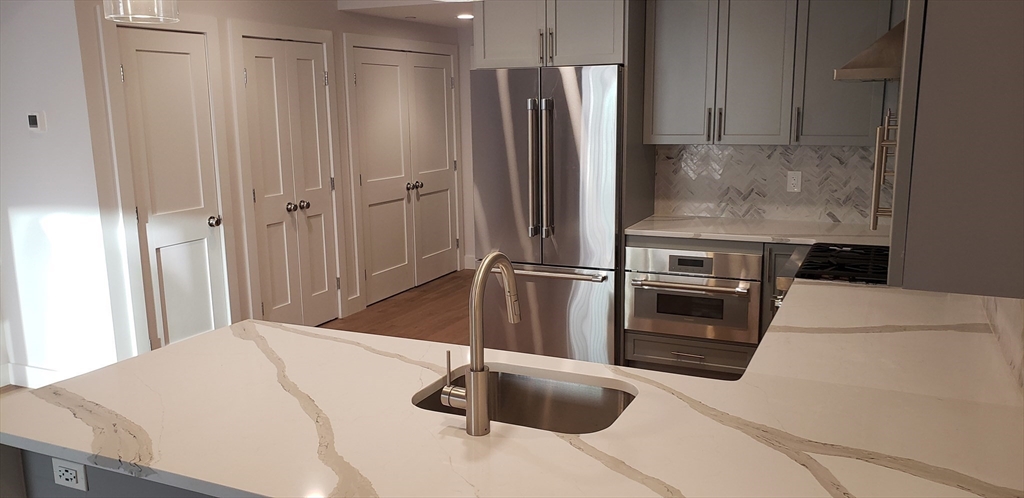 50 Hichborn Street, Unit 311 Boston, MA 02135 - Photo 9 of 19 a kitchen with granite countertop a refrigerator and a sink