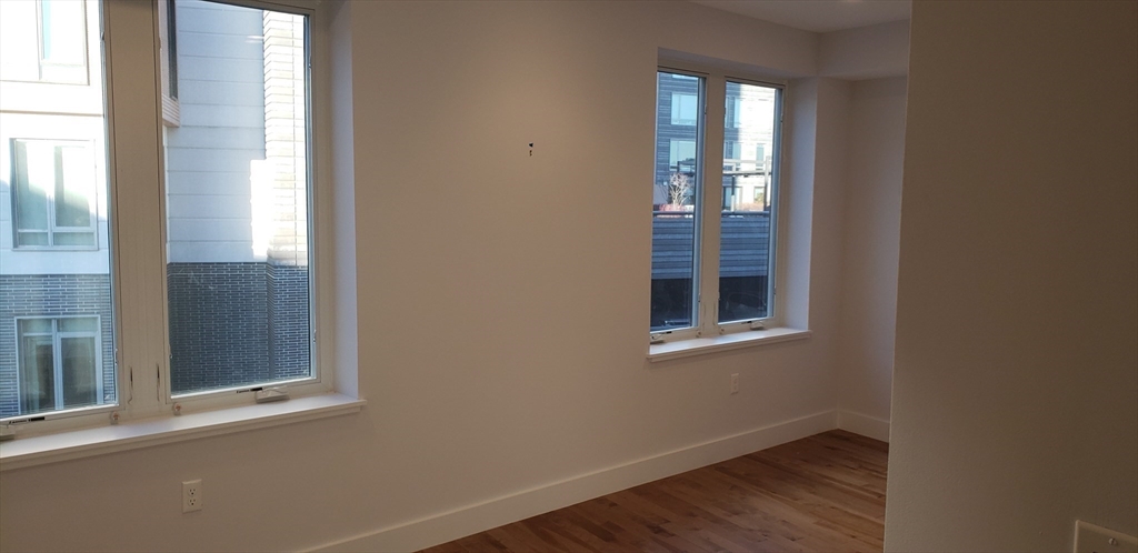 50 Hichborn Street, Unit 311 Boston, MA 02135 - Photo 10 of 19 a view of an empty room with wooden floor and a window