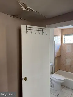 a white toilet sitting next to a bathroom sink and a shower