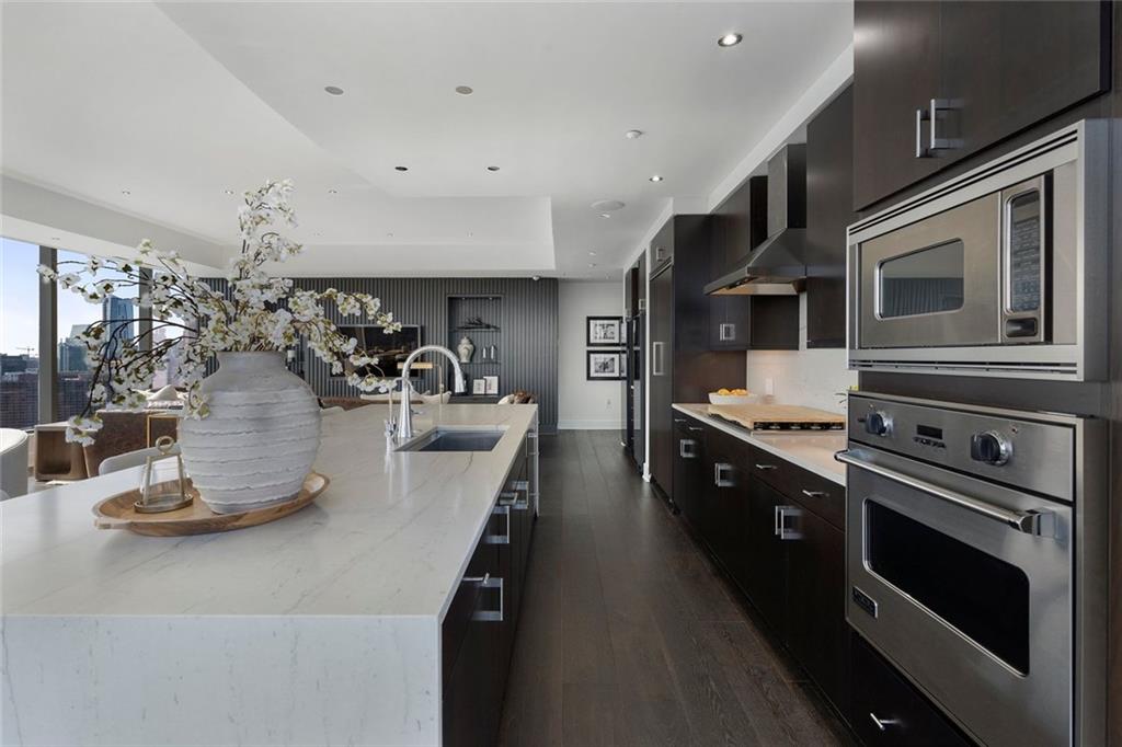 3630 Peachtree Road Northeast, Unit 2104 Atlanta, GA 30326 - Photo 32 of 98 a kitchen with kitchen island stainless steel appliances and wooden floor