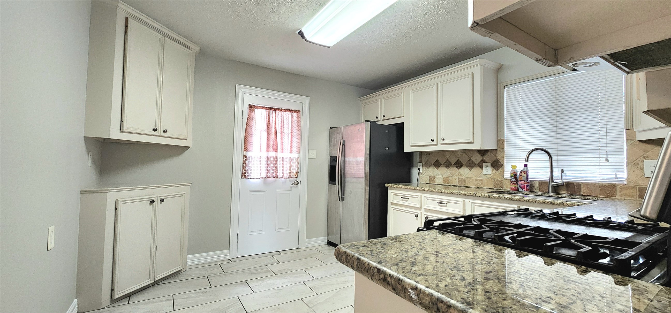 6927 Burgess Street Houston, TX 77021 - Photo 10 of 22 a kitchen with granite countertop a stove and refrigerator