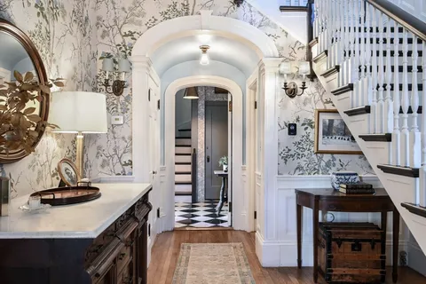 a view of a hallway with wooden floor and staircase