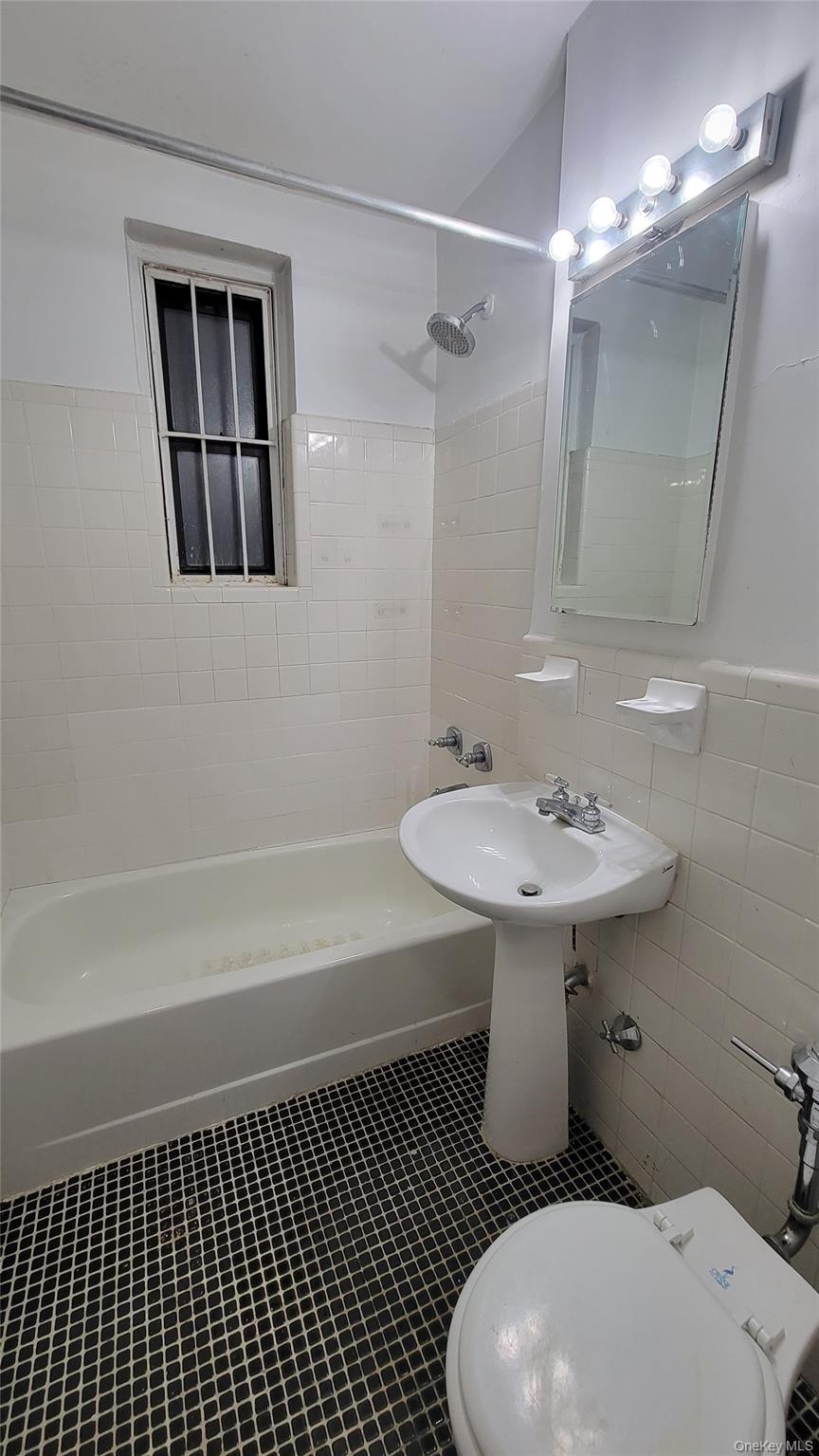 141-30 84th Road, Unit 6 Queens, NY 11435 - Photo 4 of 4 a bathroom with a sink a toilet and shower