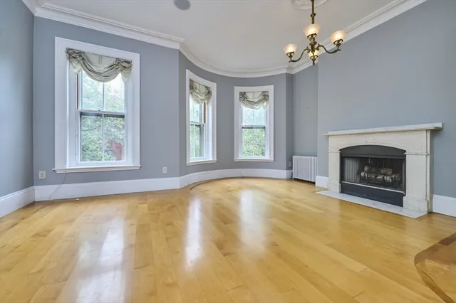 a view of an empty room with a window and fireplace
