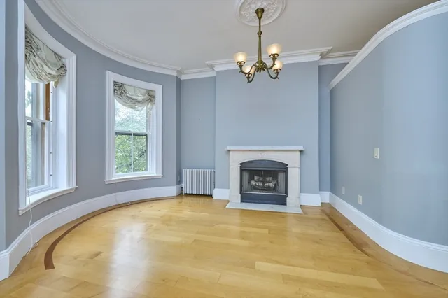 a view of an empty room with a fireplace and a window