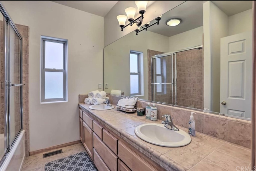 26388 Thunderbird Drive Lake Arrowhead, CA 92352 - Photo 18 of 27 a bathroom with a granite countertop double vanity sink and a mirror