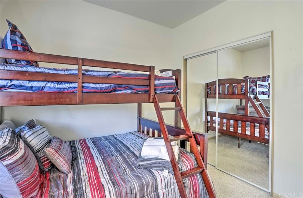 26388 Thunderbird Drive Lake Arrowhead, CA 92352 - Photo 20 of 27 a bedroom with a bed and a chandelier