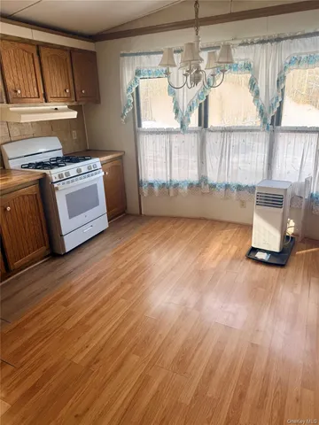 a view of a kitchen with a sink wooden cabinets and a window