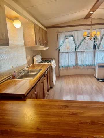 a view of a kitchen with wooden floor and a sink
