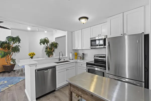 a kitchen with white cabinets and stainless steel appliances