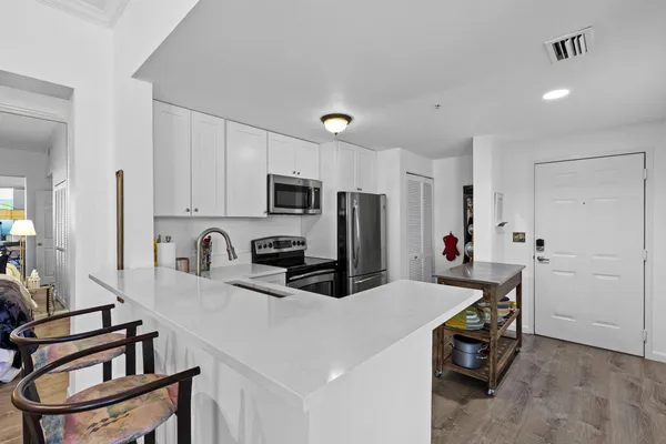 a kitchen with kitchen island a sink appliances and cabinets
