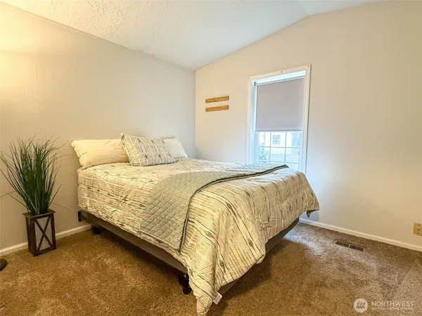 a bedroom with a bed and a potted plant
