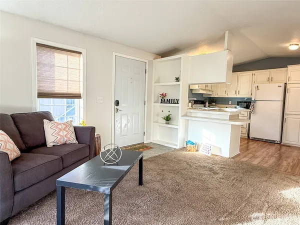a living room with furniture and a kitchen view