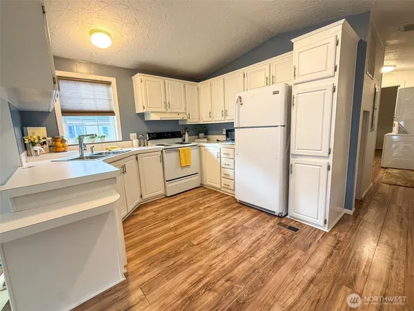 a kitchen with granite countertop appliances a sink and a refrigerator