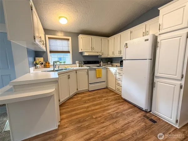 a kitchen with white cabinets and white appliances