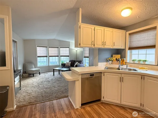 a kitchen that has a sink and chairs in it
